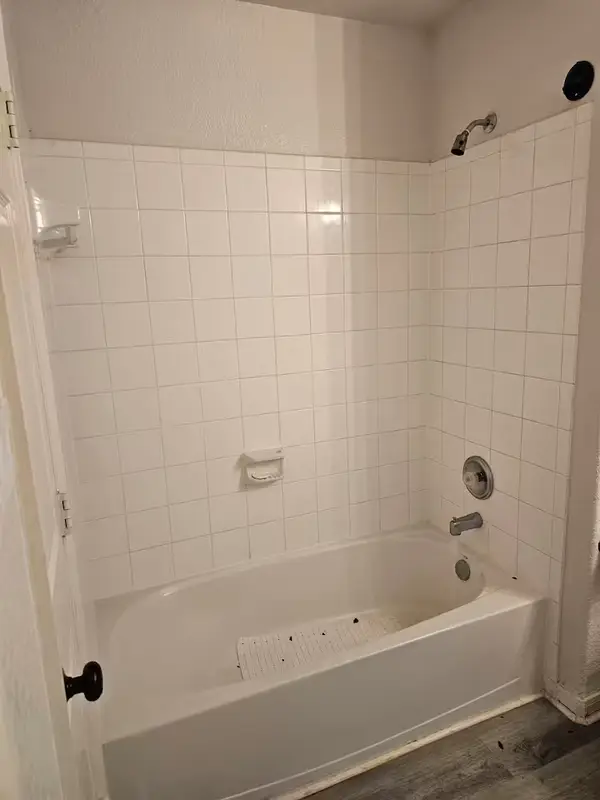 Bathroom before renovation — tub and tile surround on Sternwood Manor Dr