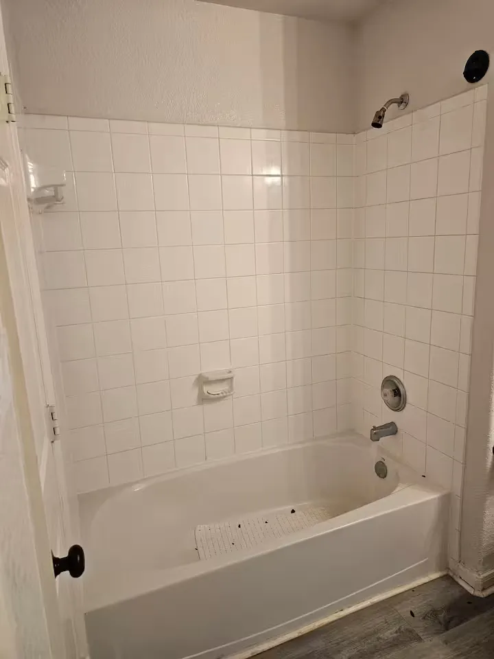 Before: the original bathtub and white tile surround