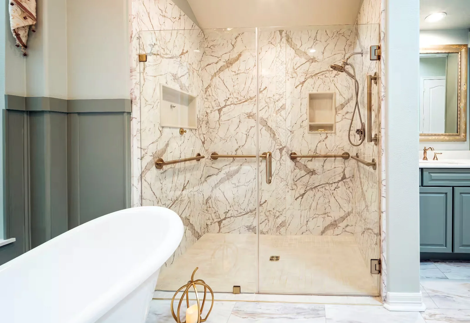 Marble-look shower with champagne bronze fixtures and recessed storage