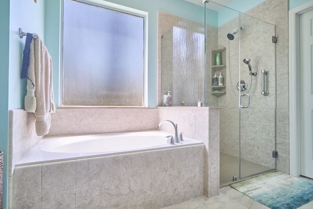 Bathtub with beige marble walls and frosted glass window