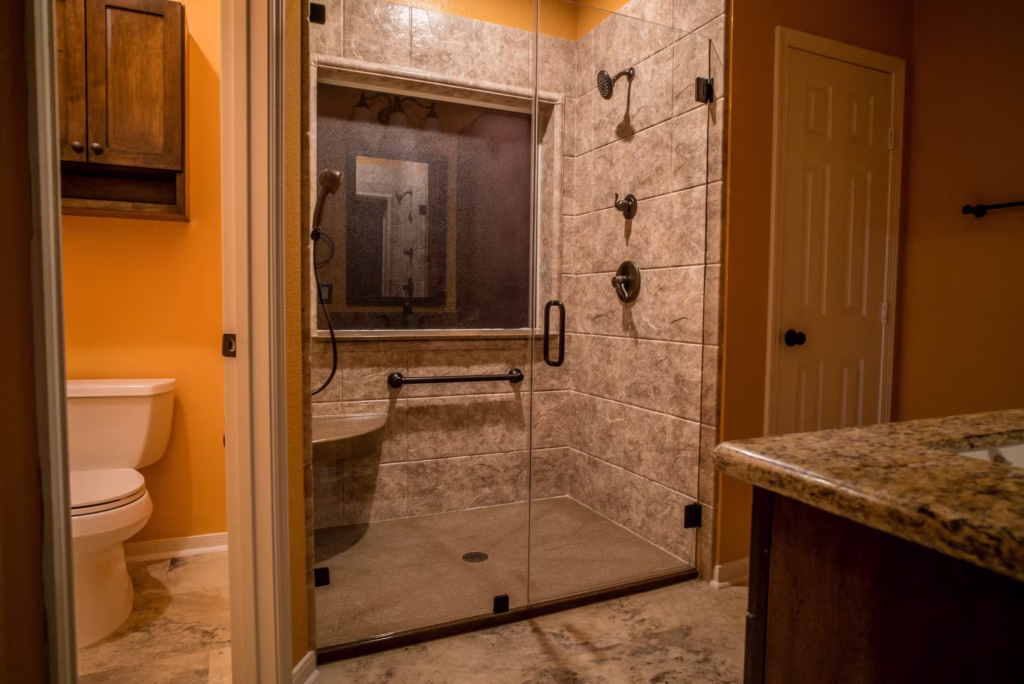 Walk-in shower with beige marble walls and glass enclosure