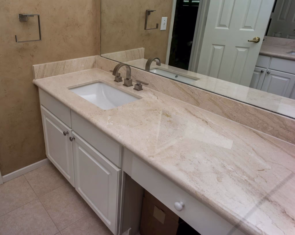 Cream vanity with beige marble countertop and chrome faucet in Houston remodel