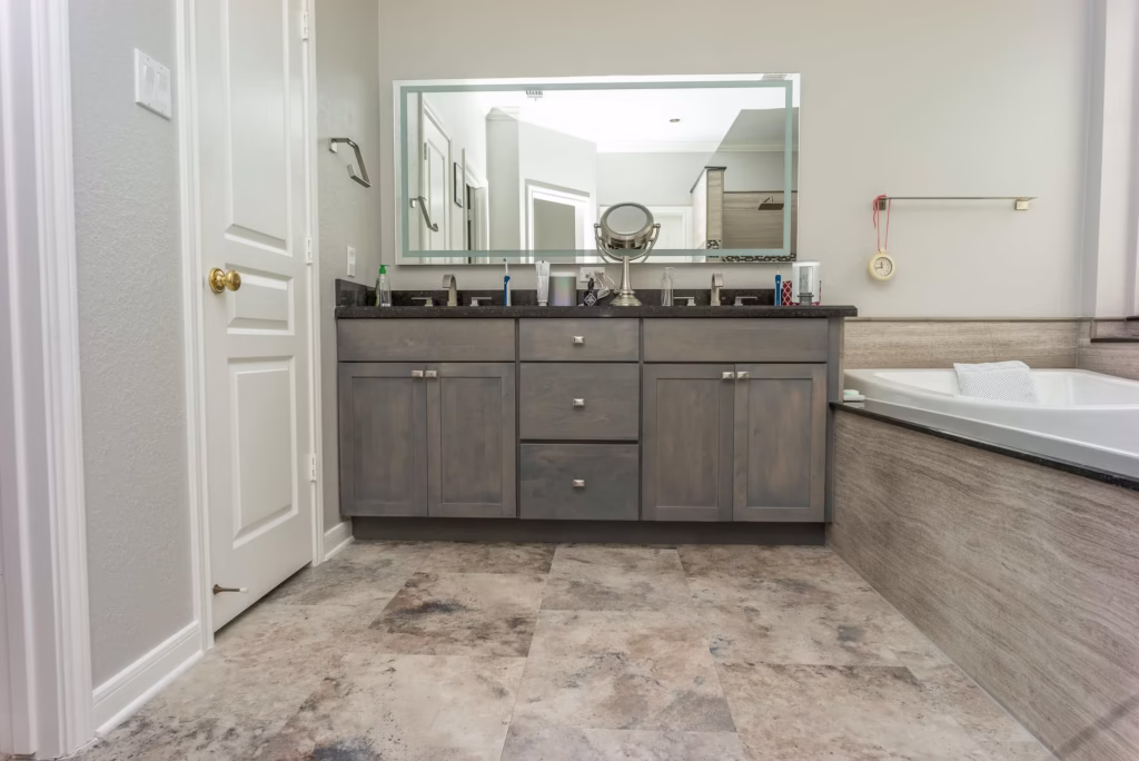 Dark gray double vanity with white countertop and center drawers in remodeled bathroom