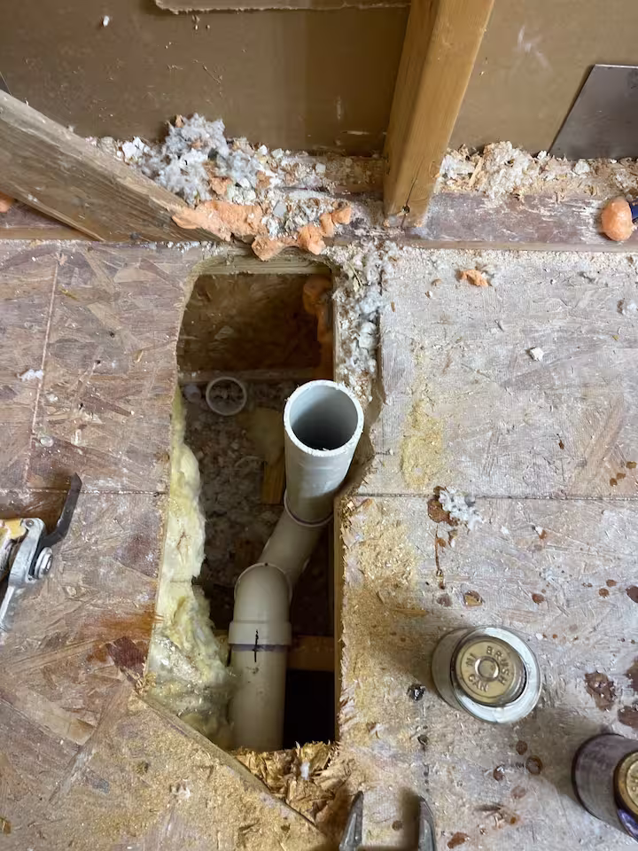 Plumbing floor cutout for drain replacement in Houston bathroom remodel
