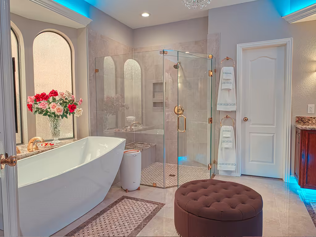 Luxury bathroom remodel with freestanding tub, frameless glass shower, LED accent lighting, and gold fixtures
