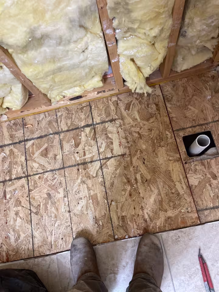 Bathroom floor prep with exposed subfloor during Houston bathroom renovation