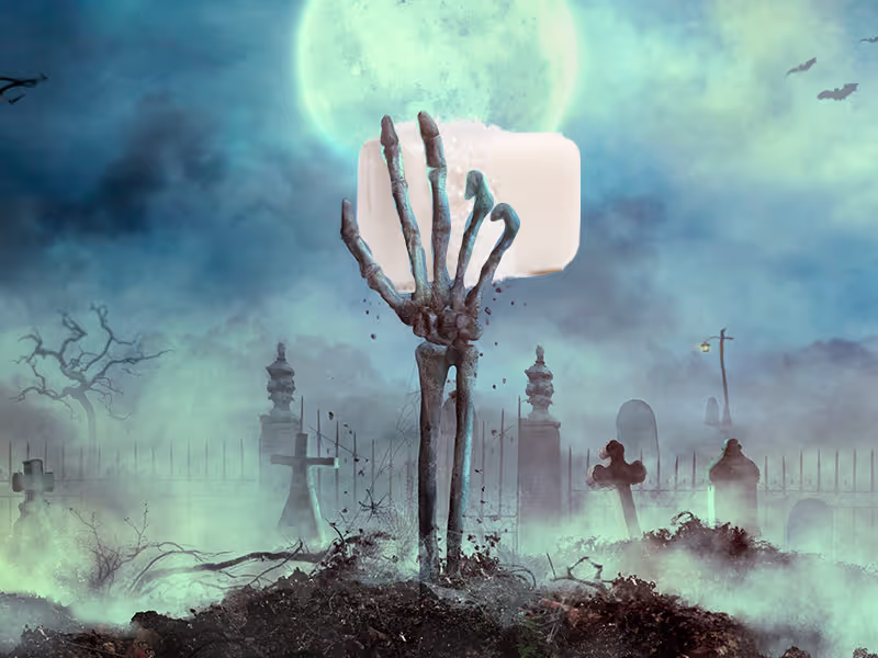 Zombie hand rising from the ground holding a document against a spooky background.