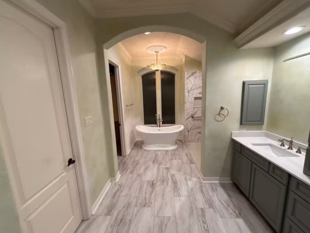 Luxury bathroom with freestanding tub and arched entry