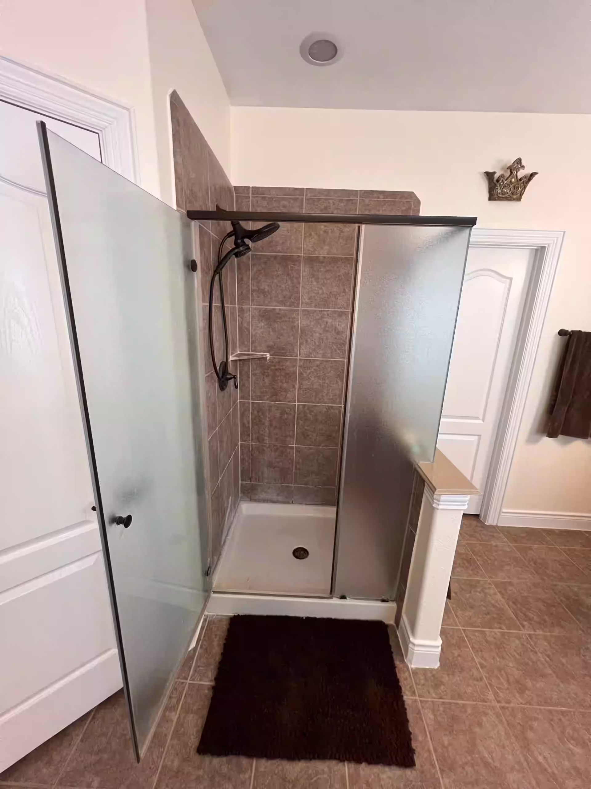 Old brown tile shower before bathroom renovation in Houston