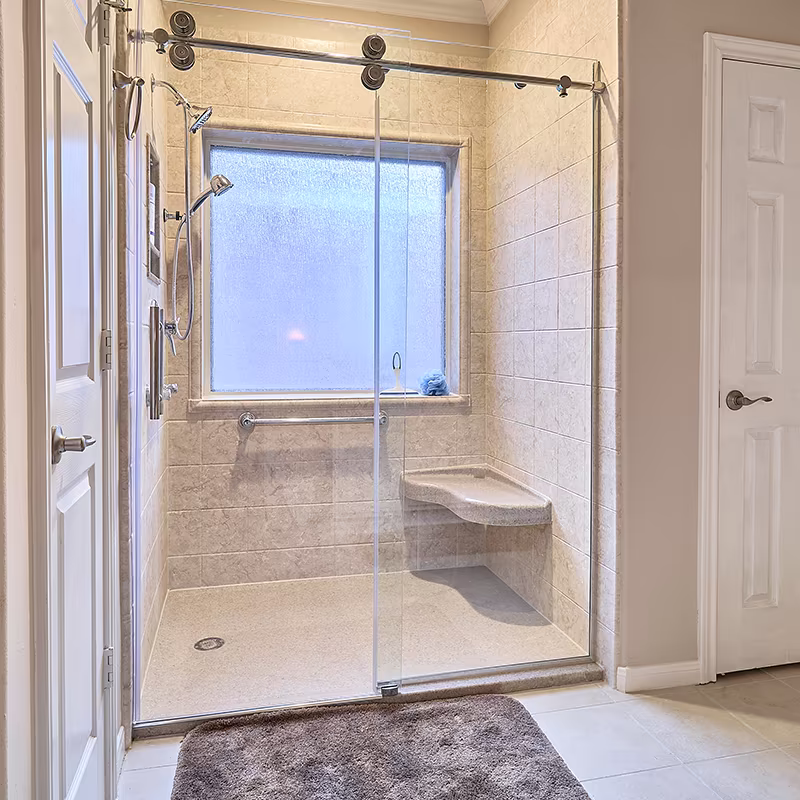 Walk-in shower with barn-style sliding glass door and built-in seat