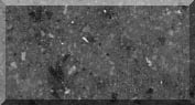 Gray textured stone surface with small white specks.